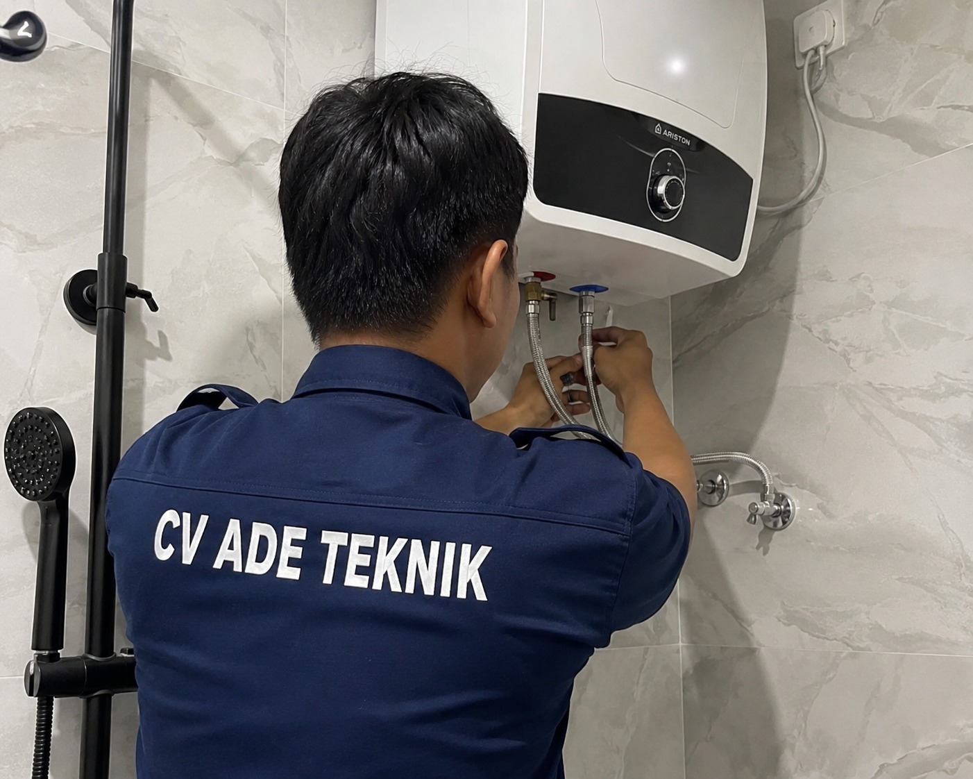 Teknisi Ade Teknik sedang memperbaiki water heater